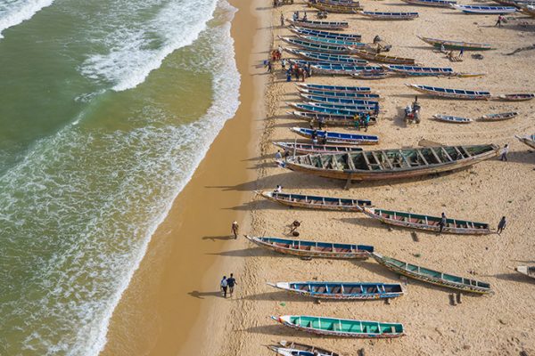 Aerial view of fishing village, pirogues fishing boats in Kayar, Aerial view of fishing village, pirogues fishing boats in Kayar, Senegal. Photo made by drone from above. Africa Landscapes.