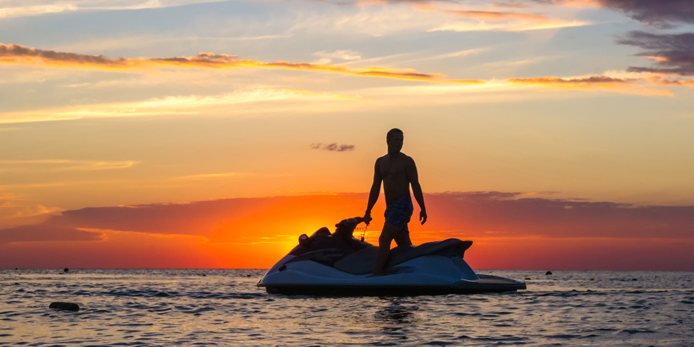 silhouette of a man on a jet ski in the sun