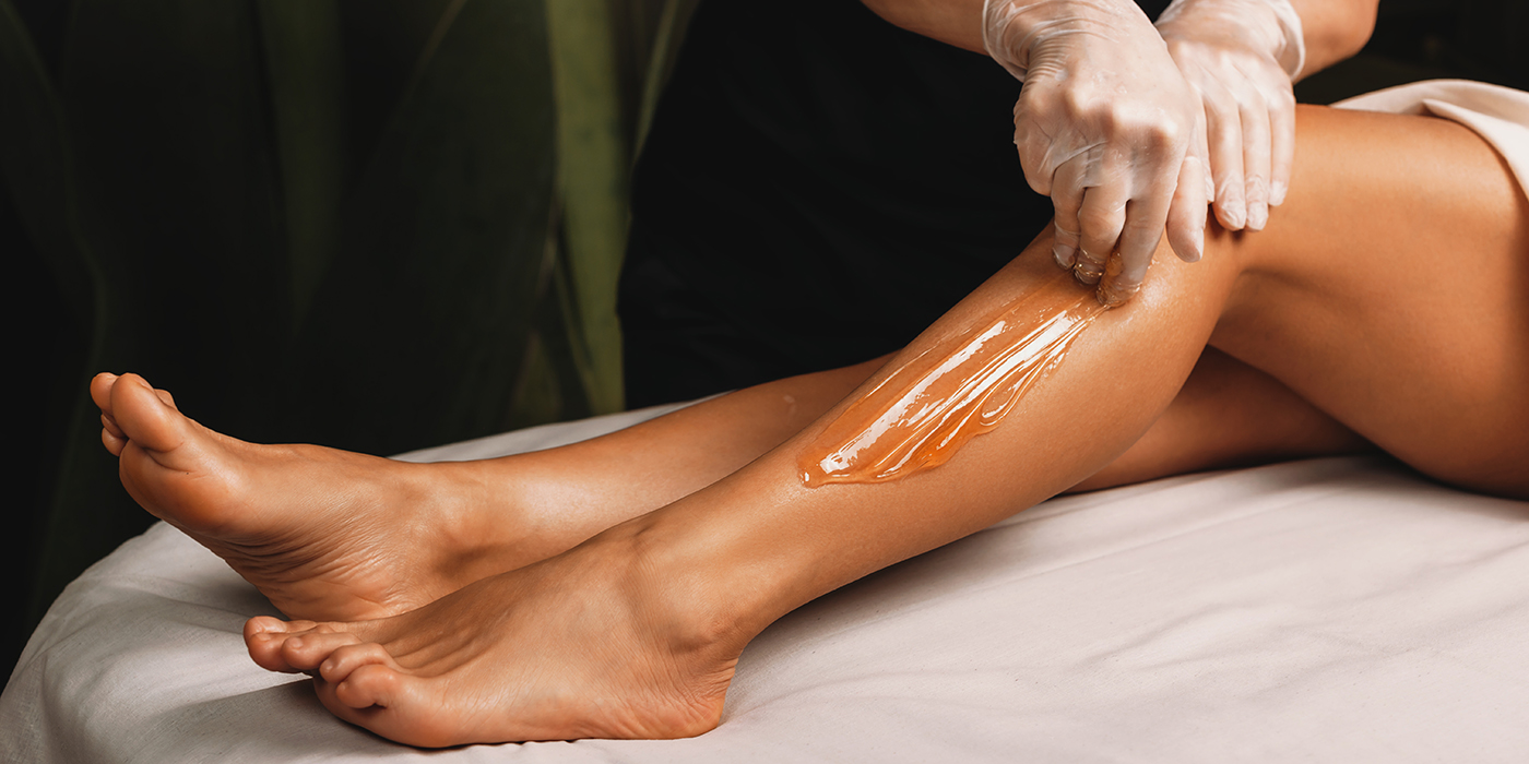 Young caucasian girl having epilation procedures with sugar at spa salon