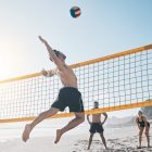 Joueur de beach-volley au smash sur une plage du Sénégal
