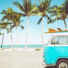 Van et planche de surf sur une plage tropicale